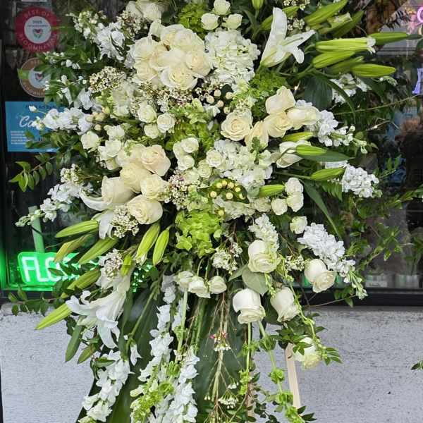Large white floral standing spray on a wooden easel