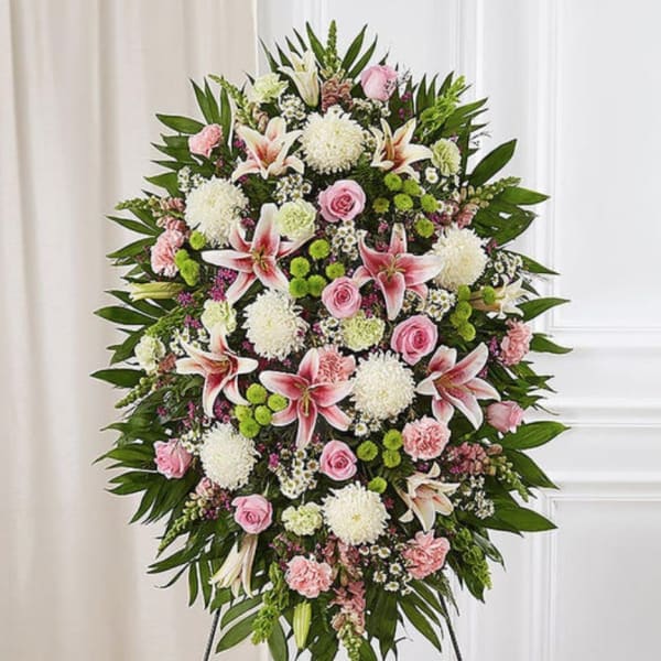 Standing floral spray with pink lilies, roses, and white mums on an easel