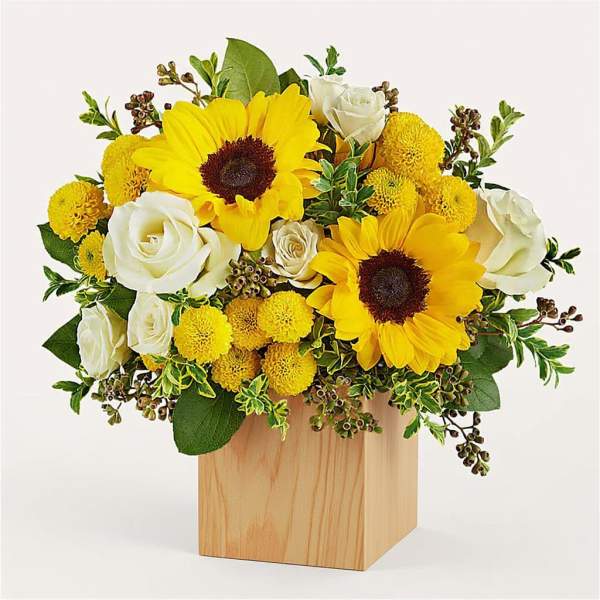 Yellow sunflowers and white roses in a wooden box