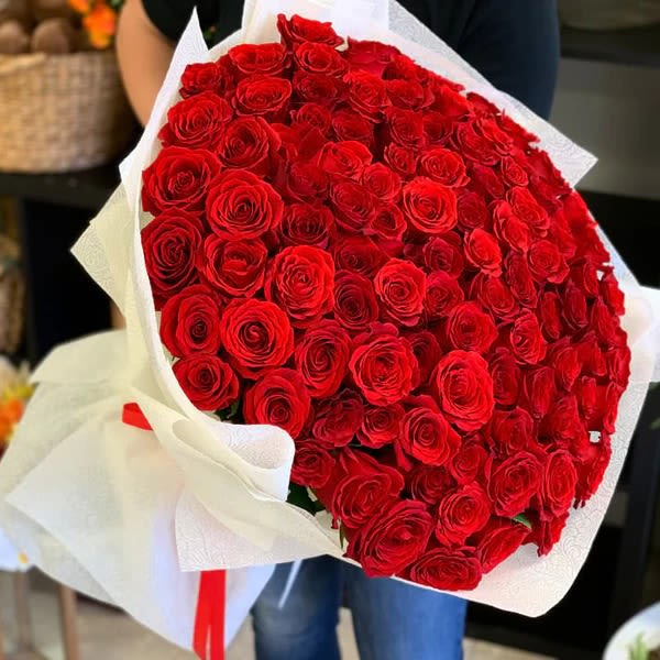 Large bouquet of red roses wrapped in white paper