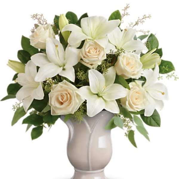 White lilies and cream roses in a gray vase