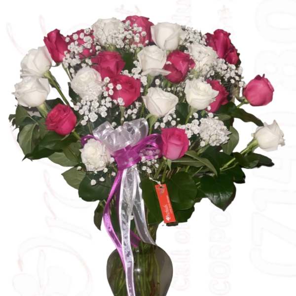 Bouquet of pink and white roses in a glass vase with ribbon