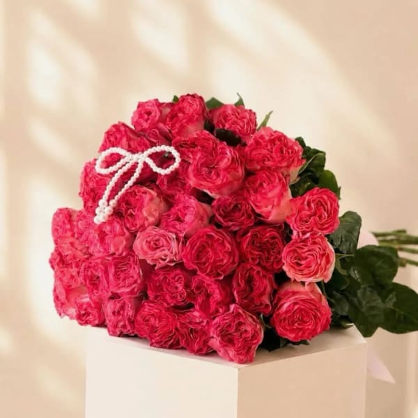 Bouquet of bright pink roses with a white beaded bow