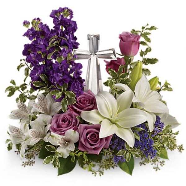 Purple and white floral arrangement with a silver cross centerpiece