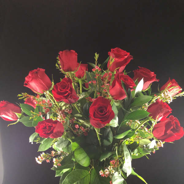Red roses arranged in a clear glass vase