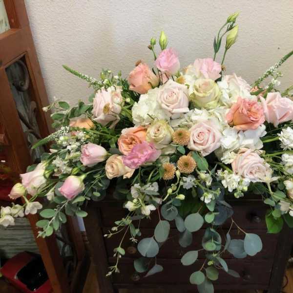 Large pastel floral arrangement with roses and white blooms