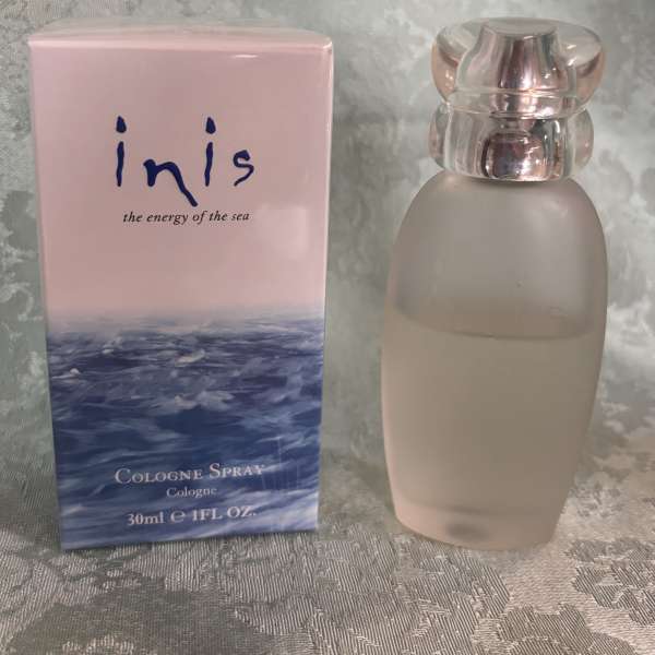 Pink cologne box beside a frosted glass perfume bottle