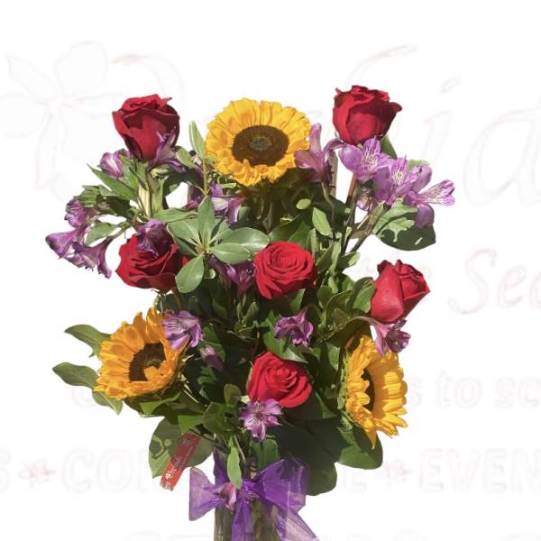 Bouquet of red roses and sunflowers in a glass vase with a purple ribbon