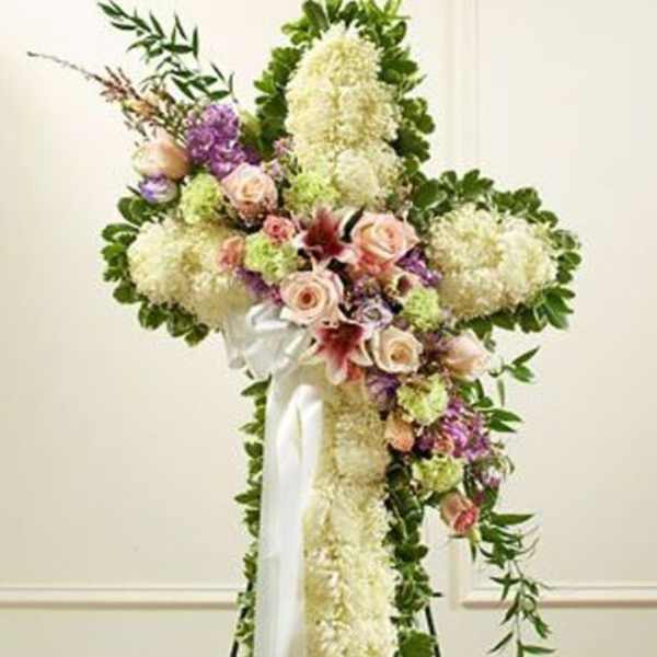 Standing floral spray with white and pastel flowers on a white ribboned easel