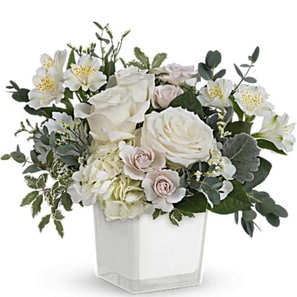 White floral arrangement in a clear square vase