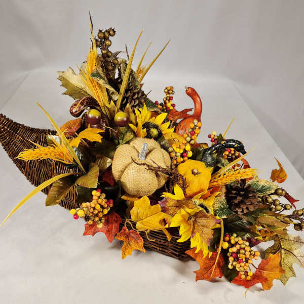 Autumn basket arrangement with pumpkins, sunflowers, pinecones, and fall leaves
