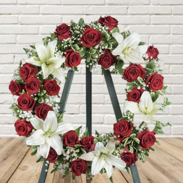 Red rose and white lily wreath on a stand