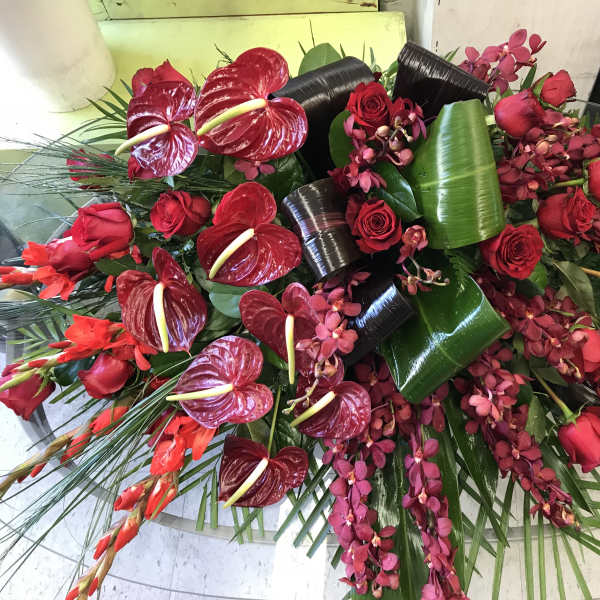 Large red floral arrangement with roses, orchids, and anthuriums
