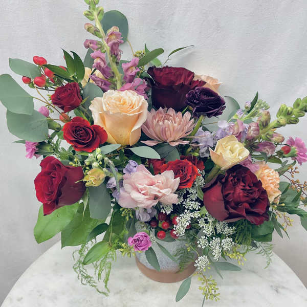 Mixed bouquet of roses and pink blooms in a vase