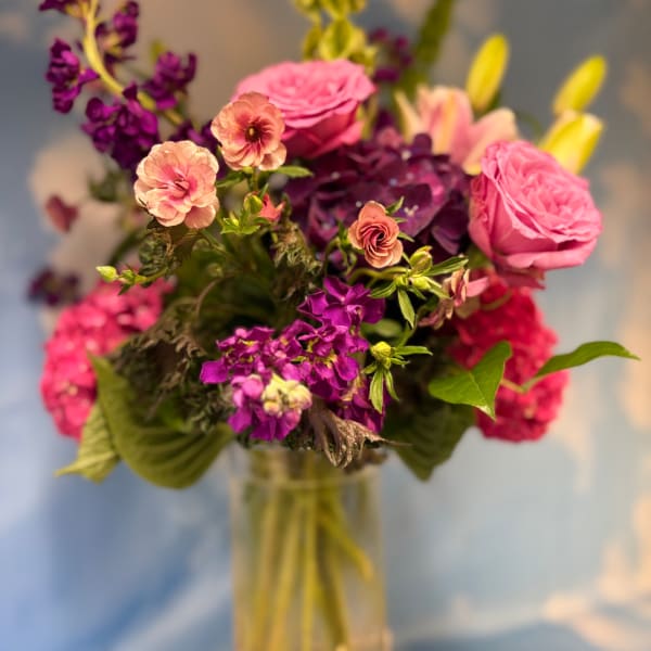 Pink and purple mixed bouquet in a clear glass vase