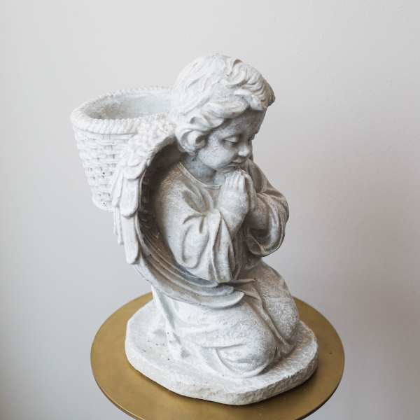 White angel figurine planter with a woven basket on its back