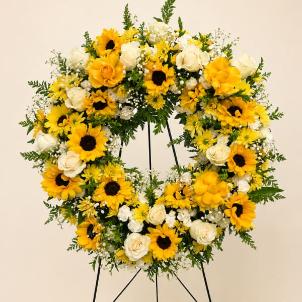 Yellow and white floral wreath on a stand