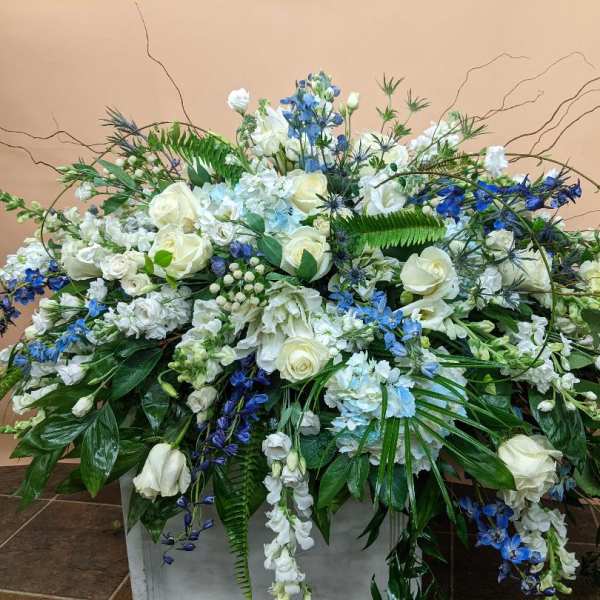 Large white and blue floral arrangement in a rectangular container