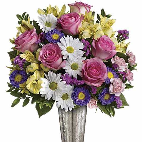 Pink roses and mixed daisies in a tall silver vase