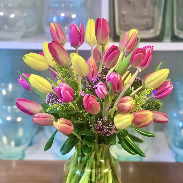 Bouquet of pink and yellow tulips in a glass vase