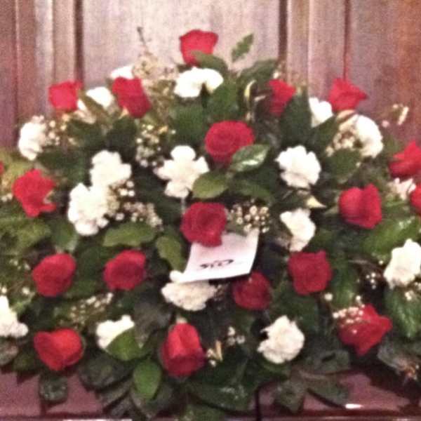 Large red and white rose arrangement on a casket