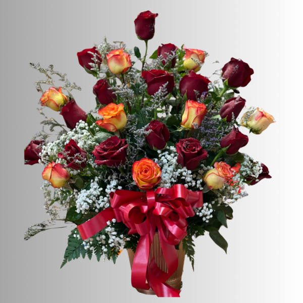 Bouquet of red and orange roses in a vase with a red ribbon