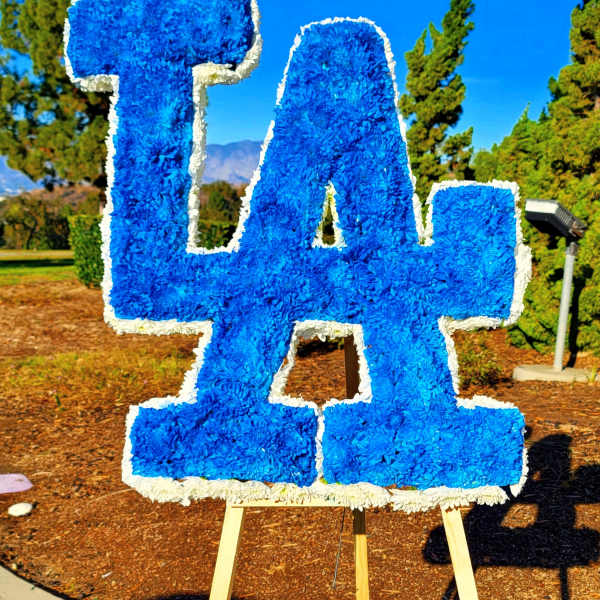 Large blue floral "LA" sign on an easel outdoors
