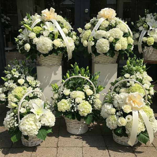 White floral basket arrangements with ribbons and lilies