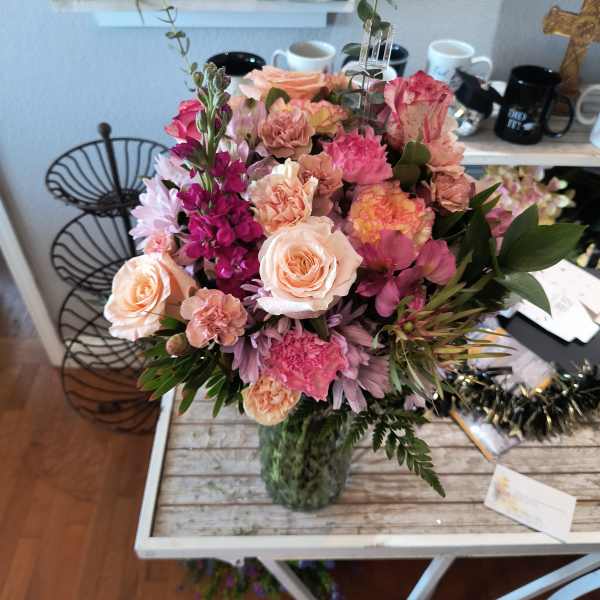 Mixed pink and peach flower bouquet in a glass vase