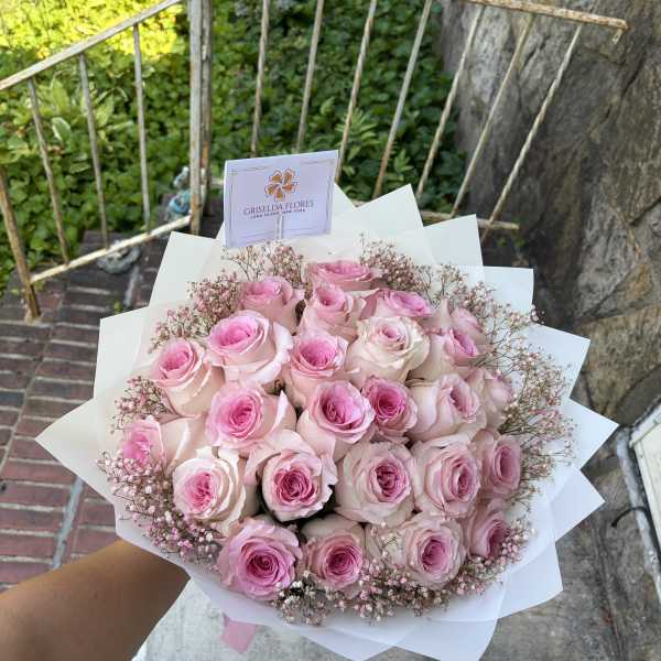 Bouquet of pink roses with baby's breath in white wrap