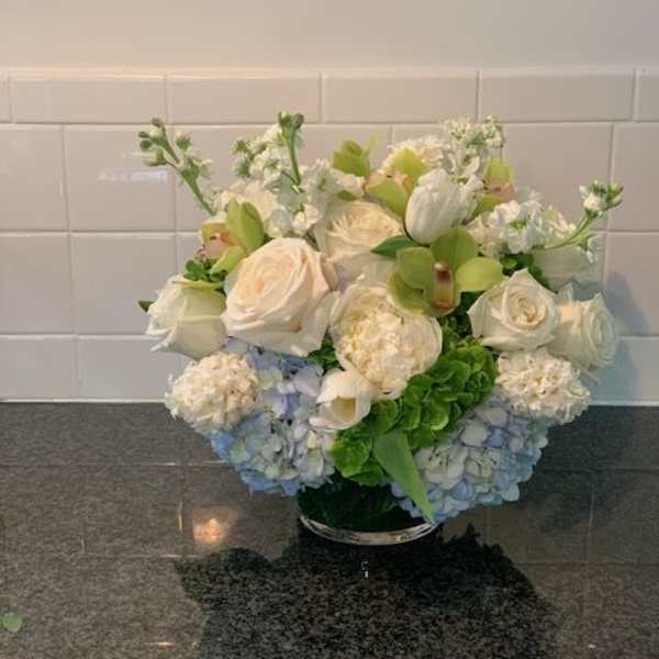 White and blue floral arrangement in a low vase