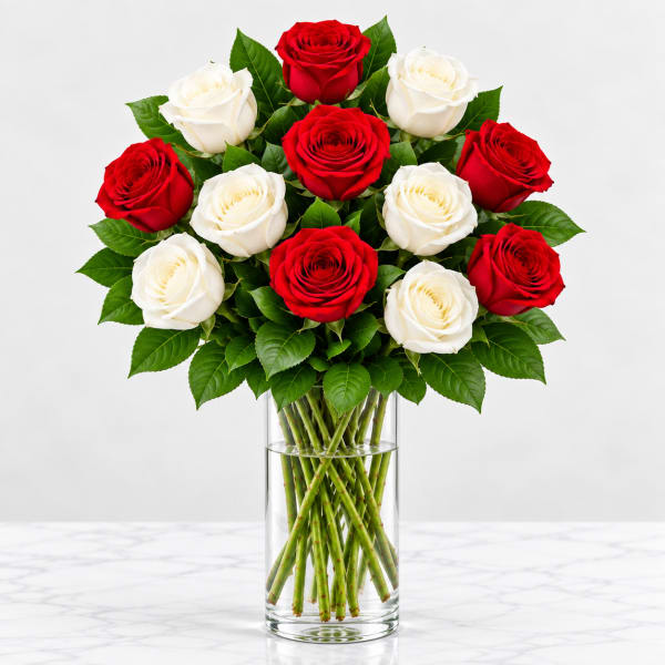 Red and white roses arranged in a clear glass vase