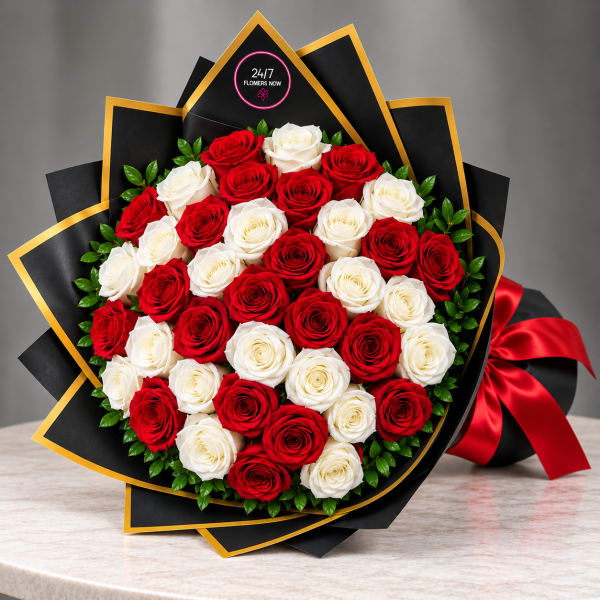Bouquet of red and white roses wrapped in black paper with gold trim