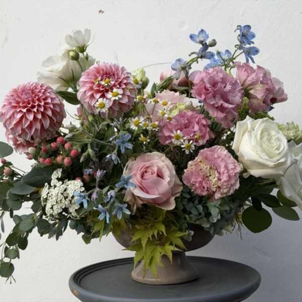 Mixed bouquet of pink and white flowers in a pedestal vase