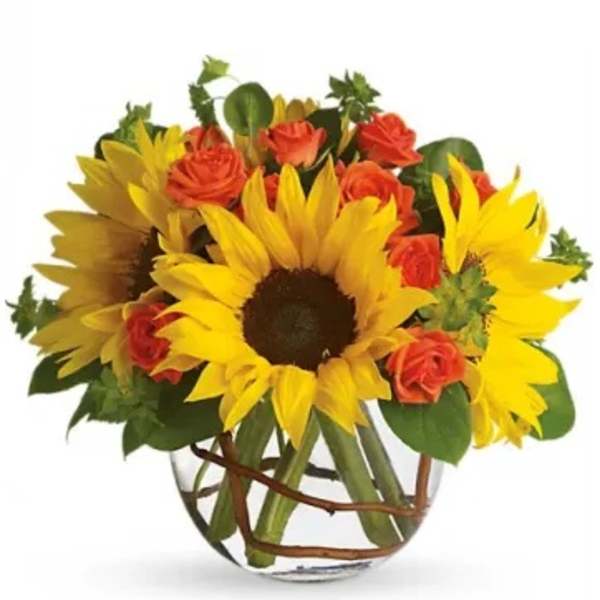 Sunflowers and orange roses arranged in a clear glass vase