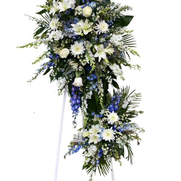 Standing floral spray with white and blue flowers on a white easel