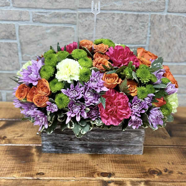Colorful mixed flower arrangement in a rustic wooden box