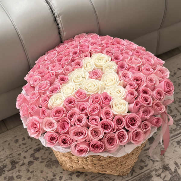 Round basket arrangement of pink and white roses