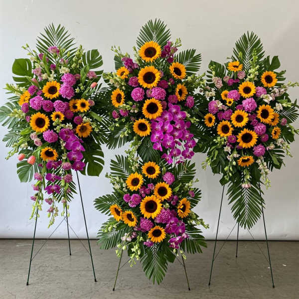 Four standing floral sprays with sunflowers and purple orchids