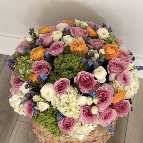 Large basket arrangement of pink, white, orange, and green flowers