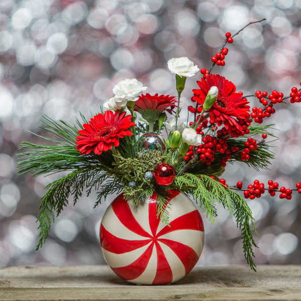 Red and white floral arrangement in a peppermint-striped vase