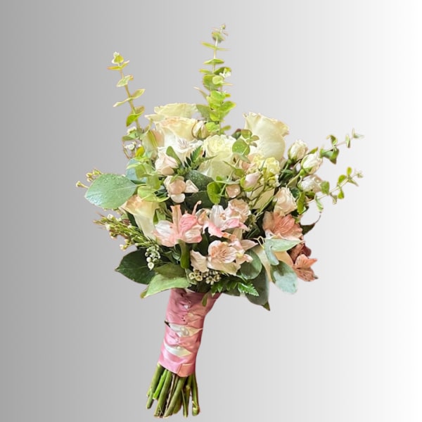 Hand-tied bouquet of pale pink and cream flowers with a pink ribbon wrap
