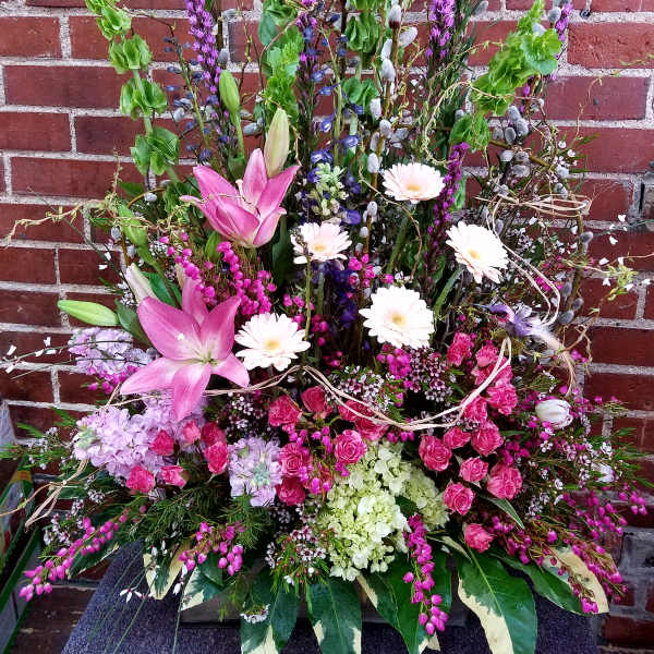 Tall mixed floral arrangement with pink lilies and white daisies
