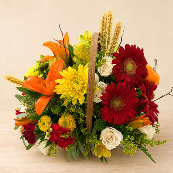 Basket arrangement with red gerbera daisies, orange lilies, and yellow mums