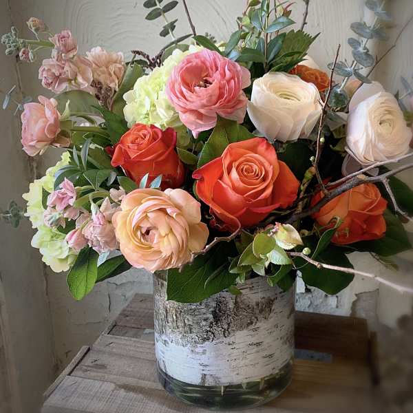 Mixed bouquet of roses and hydrangeas in a birch-style vase