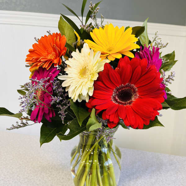 Colorful gerbera daisy bouquet in a clear glass vase