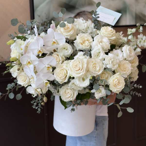 Large white bouquet of roses and orchids in a white box
