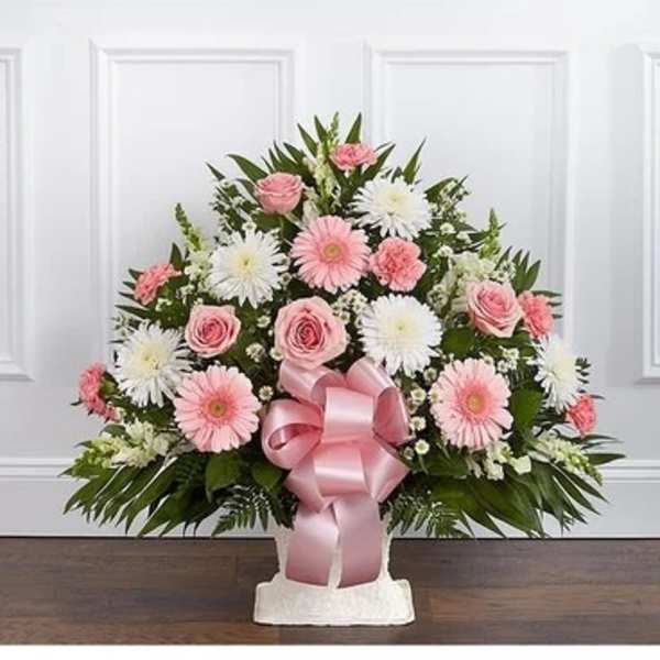 Pink and white floral arrangement with a pink ribbon bow in a white container