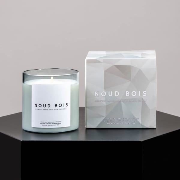 Scented candle in a glass jar beside its boxed packaging