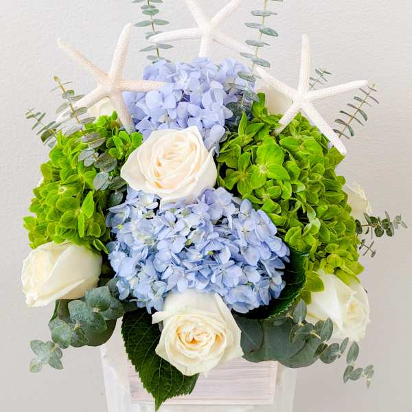 Bouquet of blue hydrangeas and white roses with starfish accents